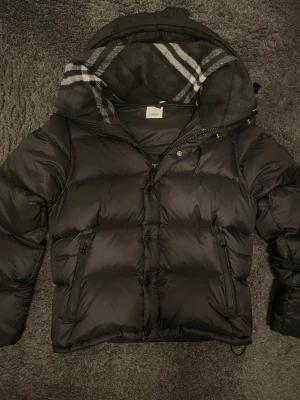 Burberry puffer - Säljer min svarta vinterjacka från Burberry. Jackan är i bra skick och har avtagsbara armar som gör den till både en vinterjacka men en väst också! Väldigt varm och fleece material på luvan och i nacken! Tveka inte på att ställa frågor vid funderingar!🙌🏼