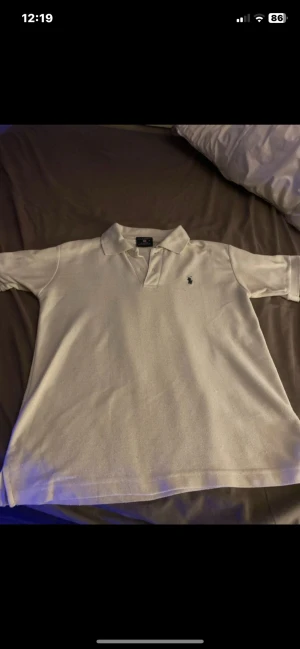 Vit Polo Sport piké i bomull - Vit pikétröja från Polo Sport i 100% bomull med klassisk krage och kort ärm. Broderad marinblå logga på bröstet. Enkel och clean stil som funkar året runt. Polon är lite nopprig men annars inget fel!