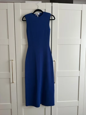 Blå ärmlös klänning med öppen rygg - Aldrig använd klänning ä, från & Other Stories i storlek XS. Materialet är stretchigt och figurnära, skulle passa även S.