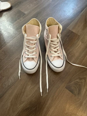 Ljusrosa Converse Str 39 - Säljer ett par Converse All Star ljusrosa💕Skorna har vit gummisula, rund tå, vita snören och silverfärgade öljetter. Ikonisk Converse-logga på sidan och bak. Super fina och knappt använda🤗