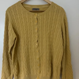 Gul kabel stickad kofta - Gul kabel stickad kofta . Storlek XL men passar löst på mig som bär S