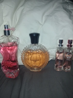 Fyra snygga damparfymer säljes - Samling med fyra damparfymer: Spartanian Lady, NG Bella Vida, NG Dominatto Woman och en okänd med rosa innehåll. Perfekt för dig som vill testa olika dofter och hitta din favorit. Volym och ingredienser syns ej på bilderna.