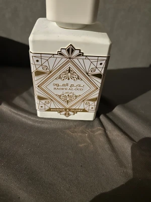 Badee Al Oud Honor & Glory - Snygg parfym från Lattafa med stilren design och orientaliska detaljer. Flaskan har texten 'Honor & Glory' och passar dig som vill sticka ut med något unikt. Perfekt för dig som gillar trendiga accessoarer.