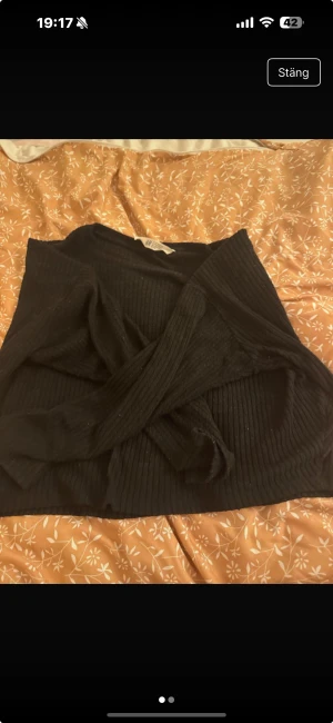 Svart ribbad stickad tröja H&M - Svart stickad tröja från H&M i storlek M. Tröjan har ribbad struktur och långa ärmar, perfekt för dig som gillar en enkel men snygg look. Passar dig som vill ha en klassisk svart tröja med lite extra känsla tack vare ribbningen.
