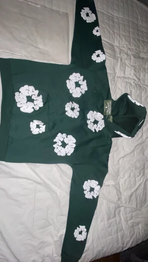 Grön hoodie från Denim Tears med blommor - Tröjan i 10/10 i skick och aldrig använt, finns inga defekter alls. Pris int hugget i sten så det är bara att skriva eller buda