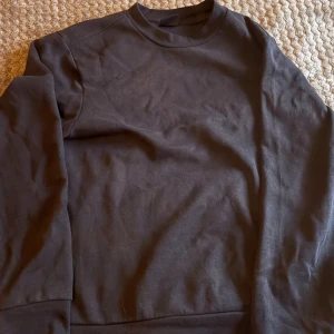 Svart sweatshirt från MNG Essentials - En stilren svart sweatshirt från MNG Essentials i regular fit. Tröjan har rund hals och långa ärmar, tillverkad i mjuk bomull som är skön mot huden. Perfekt för dig som gillar enkel och clean stil. Passar dig som vill ha en basic tröja i garderoben.