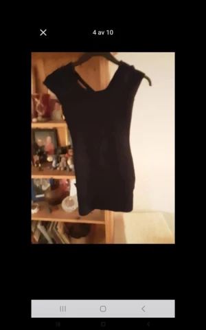 Svart kortärmad klänning - En stilren svart klänning med korta ärmar och figurnära passform. Klänningen har en enkel design och är perfekt för dig som gillar minimalistisk stil. Passar dig som vill ha en klassisk look med modern känsla.