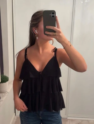 Svart volangtop från Elli White - Supersöt svart topp från Elli White! Perfekt till middagar eller fest!🩷🩷