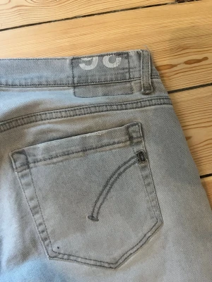 Grå dondup jeans straight fit - Snygga grå jeans från dondup med raka ben och klassisk femficksdesign. Jeansen har diskret Replay-logga på bakfickan och är tillverkade i mjukt bomullsmaterial. Perfekt för dig som gillar stilrena och enkla jeans med en modern touch.