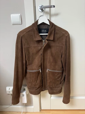 Mockajacka från Replay - Snygg brun mockajacka från Replay med klassisk krage och två stora fickor framtill med silvriga dragkedjor. Fick denna i present och den blev tyvärr för kort för mig efter aldeles för få användningar. Nypris och även slutsåld för 4000 kr på MQ!