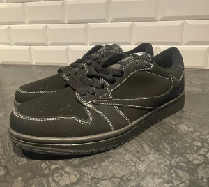 Svarta Nike Jordan 1 Low Travis Scott  - Säljer nu DESSA Nike Jordan 1 Low Travis Scott sneakers i svart mocka! Snöre osv med följer. Priset är inte hugget i sten! 