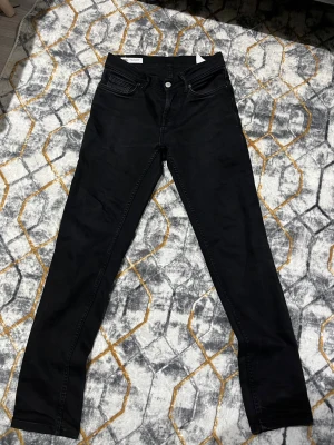 Svarta skinny jeans från Zara - Svarta jeans från Zara med klassisk femficksdesign och smal passform. Jeansen har en enkel look med svarta sömmar och knappstängning fram. Materialet är mjukt och stretchigt för extra komfort. Perfekta för dig som gillar en clean och stilren vibe.