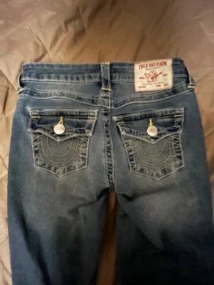 True Religion Becca Bootcut Jeans - Säljer ett par blå True Religion Becca jeans i bootcut-modell med midwaist då de tyvärr inte passar, Använda fåtal gånger toppen skick😁