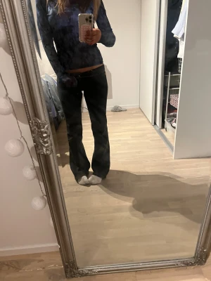 Svarta bootcut jeans låg midja - Säljer ett par svarta jeans med låg midja och bruna sömmar,bootcut. Jeansen har klassisk femficksdesign, knapp och dragkedja framtill. Snygg passform som sitter tajt över höften och blir vidare nedtill. På bilden är dom nervikta men har även väldigt låg midja endå! Skriv för fler bilder ev.mått