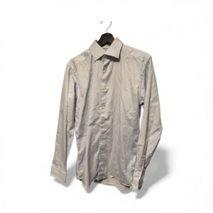 Ljusblå slim fit skjorta från Eton - Snygg ljusblå skjorta från Eton i slim fit-modell. Skjortan har klassisk krage, långa ärmar och knappar framtill. Tillverkad i mjuk bomull som känns skön mot huden. Perfekt för dig som gillar stilrena och enkla plagg med bra passform.