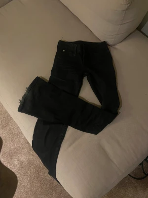 Cheap Monday svarta Booty jeans - Svarta jeans från Cheap Monday, modell Booty. Snyggt smal passform med klassisk femficksdesign och rå kant vid benslut. Jeansen är tillverkade i stretchig bomull för extra komfort och har en enkel look som funkar till allt.Kolsvarta och är i storlek 32/24 