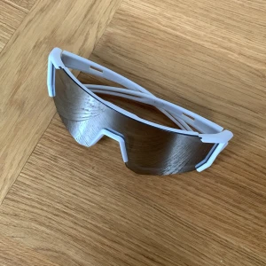 Vita Solglasögon - Säljer ett par riktigt feta sport-glasögon med vit båge och stora spegelblanka linser. De har en futuristisk, kantig design och passar perfekt för dig som vill sticka ut på träningen, cykelturen eller helt enkelt stylea till dem. Lätta och bekväma.