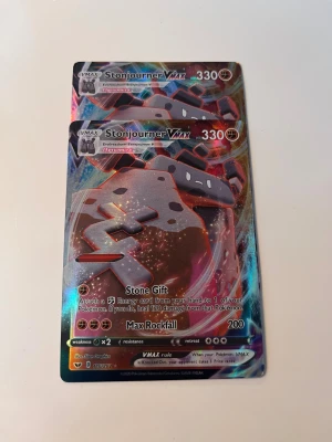 Stonjourner VMAX - Två coola Stonjourner VMAX Pokémonkort med glittrande design! Perfekt för dig som samlar eller vill boosta din lek med en stark VMAX. Korten har 330 HP och unika attacker som Stone Gift och Max Rockfall. Ett måste för Pokémon-fans!