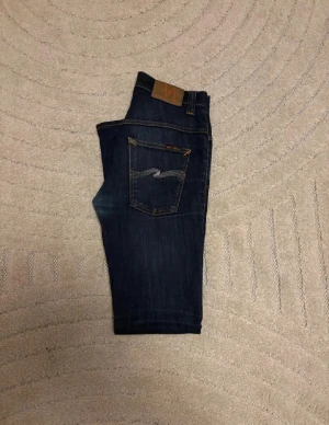 Nudie jeans (Dry & Thin Finn) - Tja, säljer dessa otroligt snygga Nudie jeans i mycket bra skick, skick = 9/10, storlek = 30/32 men sitter mer som W28, mitt pris = 600, modellen är 170, 60kg, mått A: 35 cm B: 104 cm, hör av er vid frågor eller funderingar 🤩🙌