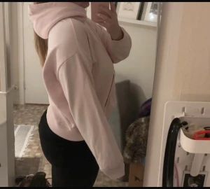 Ljusrosa hoodie med huva - Säljer en ljusrosa hoodie med stor huva och magficka. Tröjan har en loose passform och är långärmad, perfekt för chill dagar. Materialet är mjukt och känns som bomull eller polyester. Enkel och stilren design utan mönster eller detaljer.