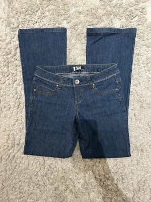 Lågmidjade utsvängda jeans - Midjemått tvärsöver: 38cm Innerbenslängd: 80cm Langd längst ner vid benet: 23,5cm