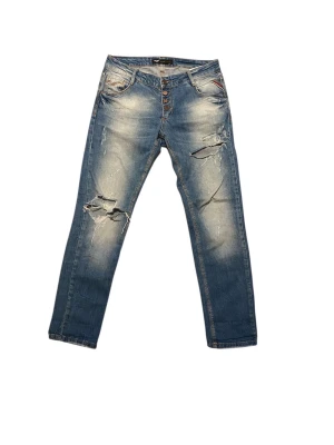 Replay jeans - Ljusblå jeans från Replay i modellen Rose, med slitningar och trasiga detaljer på benen. Klassisk femficksmodell, knäppning med fyra knappar och snyggt tvättad finish. Perfekt för dig som gillar en avslappnad och trendig look. Storleken är W28. Skriv till mig om du vill ha måtten eller om du har några andra frågor. Priset är prutbart vid enkel affär