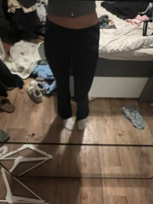 Marinblå bootcut yogapants med mid midja - Säljer ett par marinblå bootcut yogapants med mid midja. De har en tight passform över låren och blir vidare nedtill, vilket ger en snygg siluett. Materialet är stretchigt och bekvämt, perfekt för dig som gillar en stilren look.
