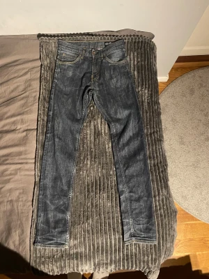 Crocker 310 Jeans mörkblå 29/32 - Snygga mörkblå Crocker 310 Skinny jeans i storlek 29/32. Modellen har smal passform, klassisk femficksdesign och kontrastsömmar. Jeansen är tillverkade i stretchigt denim för extra komfort och har en stilren look med läderpatch bak.