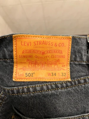Levi's 501 mörkblå jeans W34 L32 - Klassiska Levi's 501 jeans i mörkblå tvätt med raka ben och fem fickor. Jeansen har den ikoniska läderpatchen bak och synliga kontrastsömmar. Passar dig som gillar tidlös stil och vill ha ett par jeans som funkar till allt.