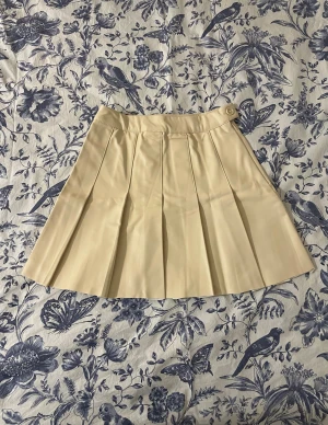 Beige kjol - Säljer en beige kjol från FB sister. Materialet liknar skinn. Aldrig använd. Prislappen sitter fortfarande kvar. Priset kan diskuteras!