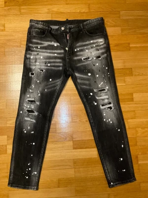 DSQ2 svarta jeans - Säljer ett par DSQ2 svarta jeans helt nya använt runt 10 gånger inga skador eller defekter på den. Perfekt passform och riktig grym kvalite på den. Taggen kommer självklart med. Svarar bara seriösa! Lite info om jeansen Midja: 92cm Längd: 110cm. För mer frågor skriv privat!