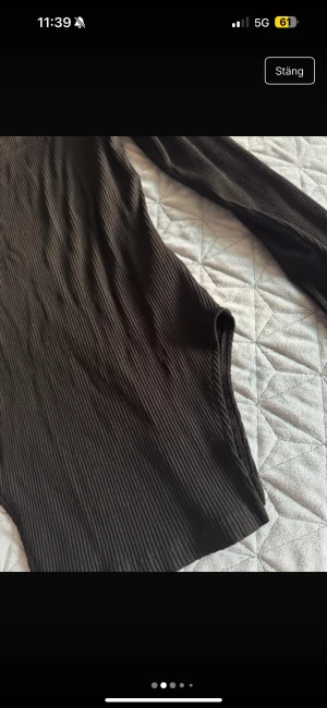 Ribbad brun långärmad klänning NA-KD - Säljer en ribbad svart långärmad tröja  från NA-KD i storlek M. Klänningen har en fyrkantig ringning och är figurnära med stretchigt material, perfekt för dig som gillar en enkel men snygg look.