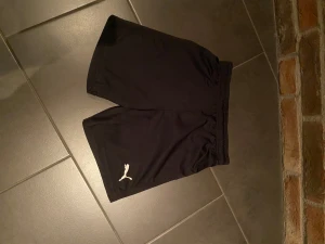 Svarta Puma shorts - Hej, säljer mina gamla Puma shorts som jag inte hunnit använda. Storleken är 11-12 år/152