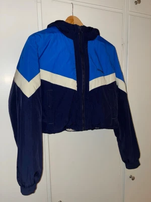 Helt ny Urban outfitters jacka st S - Säljer en snygg croppad vindjacka från Urban outfitters med chevron-detalj och huva. Jackan har dragkedja framtill och är fodrad med mjuk vit fleece. Perfekt för dig som gillar streetstyle och vill ha något som sticker ut.