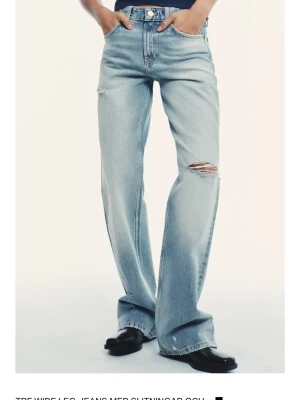 Wide leg ljusblå jeans med slitningar - Snygga ljusblå jeans från Zara helt oanvända då dem inte passade mig. Skriv om ni vill ha fler bilder på dem!