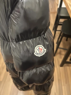 Monclerjacka  - Väldigt välhållen jacka. Haken i nacken ( kan användas för att hänga jackan på en klädkrok behöver sys fast) Jackan är väldigt varm och bekväm. Passar någon som är upp till 190 cm