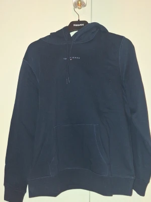 Tommy jeans hoddie  - Tommy Jeans hoodie i helt nytt skick. Hoodien är aldrig använd och har inga fläckar, slitage eller skador. Den är i en snygg och tidlös marinblå färg som passar till det mesta. Klassisk Tommy Jeans-design med hög kvalitet och bekväm passform. Storlek L, perfekt för både vardag och fritid. Ett utmärkt val för dig som vill ha en helt ny hoodie till ett bra pris.