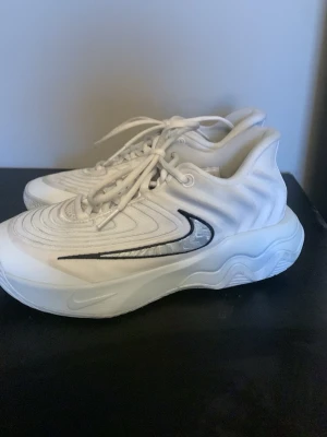 Giannis immortality 4 st 37,5 basket skor - Säljer ett par fräscha vita Nike sneakers med svart swoosh på sidan.  Pris går att diskutera eftersom att dom är lite smutsiga och att jag inte har sko lådan