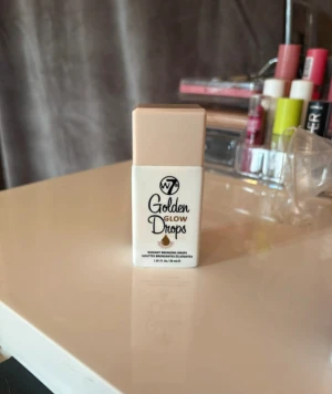 W7 Golden Glow Drops bronzer - Golden Glow Drops från W7 är flytande bronzer i en smidig beige plastflaska med skruvlock. Ger en strålande gyllene finish och kan blandas med foundation eller användas direkt på huden för extra glow. Perfekt för dig som vill ha en solkysst look.