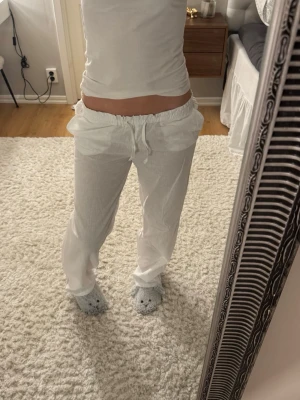 Vita linnebyxor med snörning - Säljer dessa vita linnebyxor med fickor bak och snören. Dom är lite slitna vid fötterna och har två ljusgula fläckar som inte går bort i tvätten (visas på sista bilden) 