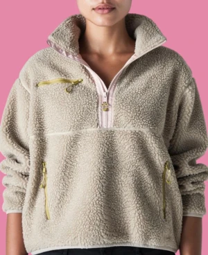 Beige fleece hoodie från Levi's - Säljer en beige fleece hoodie från Levi's med halv dragkedja i ljusrosa och tre fickor med gula dragkedjor. Tröjan har hög krage och långärmade ärmar, perfekt för kyliga dagar. Mjuk och fluffig känsla, med Levi's logga i rosa på insidan.