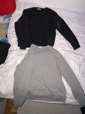 Svart och grå sweatshirt i bomull - Två stilrena sweatshirts i svart och grått, perfekta för chill dagar. Båda har rund hals och långa ärmar med ribbade muddar. Materialet är mjuk bomull som känns skönt mot huden. Passformen är normal och de är enkla att matcha med jeans eller joggers. Köper  du en får du de. För 199
