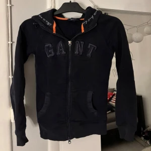 Gant Zip Hoodie XS - Hej, säljer nu min använda GANT Zip Hoodie i Mörblå, storlek XS. Den är ganska använd men ändå i bra skick, lite missfärgningar och dammi. Skriv gärna vid frågor😊