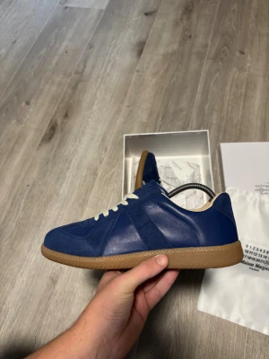Maison Margiela gats - Navy 43  - Säljer dessa Maison Margiela Gats i storlek 43. Skorna är helt oanvända och levereras med kartong och dustbags. Jag accepterar endast PayPal eftersom jag bor i Tyskland. Jag har fler än 200 byten på Vinted, så oroa dig inte!