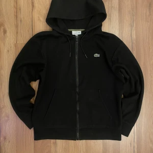 🖤 Lacoste hoodie - Storlek: M Pris: 1000 kr Snygg svart zip-hoodie med den klassiska krokodil-loggan 🐊 Mjuk, bekväm och använd bara några få gånger ✨ Perfekt för vardag eller streetwear-look 👌