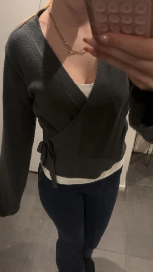 Mörkgrön omlottkofta från Gina Tricot - Säljer en mörkgrå omlottkofta från Gina Tricot i mjukt stickat material. Koftan har långa ärmar, v-ringad hals och knyt i sidan. Fin att ha med ett linne under eller utan. Säljer för jag inte anvönder :) 