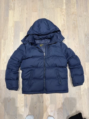 Marinblå Ralph Lauren vinterjacka - Säljer denna super feta Ralph lauren i jackan i storleken L i barn. Motsvarar väl XS i herr eller mindre. Inga defekter. Jackan är äkta. Pris kan diskuteras vid snabb affär!