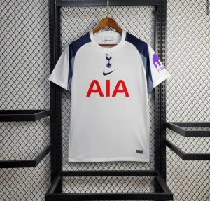 Tottenham Hotspur vit matchtröja Nike - Säljer en officiell Tottenham Hotspur fotbollströja från Nike. Tröjan är vit med marinblå detaljer på axlarna och har röd AIA-logga på bröstet. Materialet är lätt och andas, perfekt för träning eller match. Klassisk rund hals och korta ärmar.