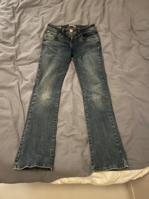 Lågmidjade LTB jeans - Säljer mina lågmidjade bootcut jeans från LTB, de är i modellen Valerie och färgen Blue Addicted.💕 De har ett hål mellan benen på högersidan men det syns inte när man har på sig dem. Midjemått rakt över: 36-37cm Innerbenslängden: 77cm, skulle säga att de är i storlek W24/L32🩷