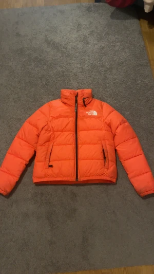 Orange pufferjacka från The North Face - Tja, säljer denna north face jackan i stl S | Den är använd ca 5 gånger och därmed i mycket bra skick | Hör av dig vid frågor